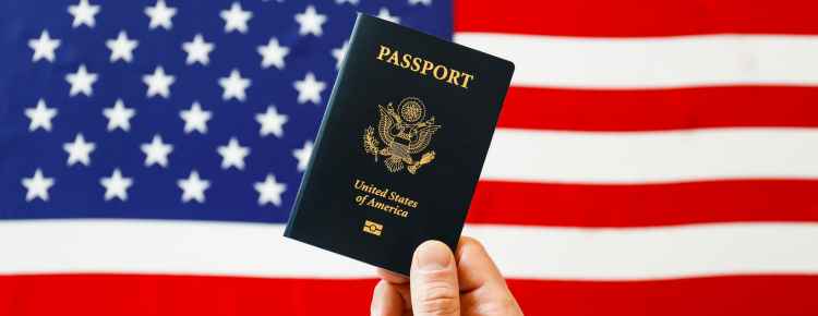 A US citizen holding a US passport and a US flag